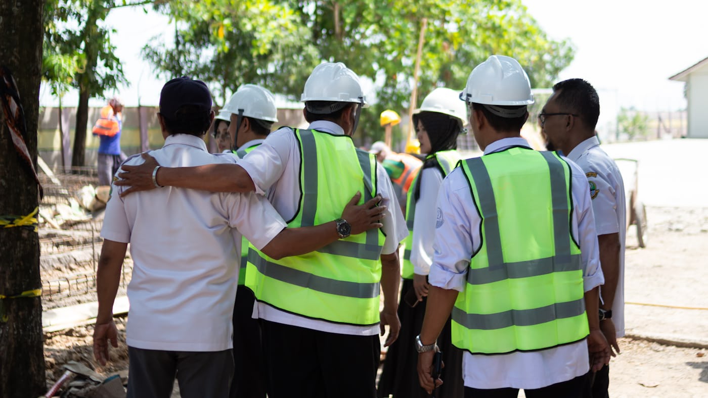 Ploeg in veiligheidshesjes in overleg op de bouwplaats